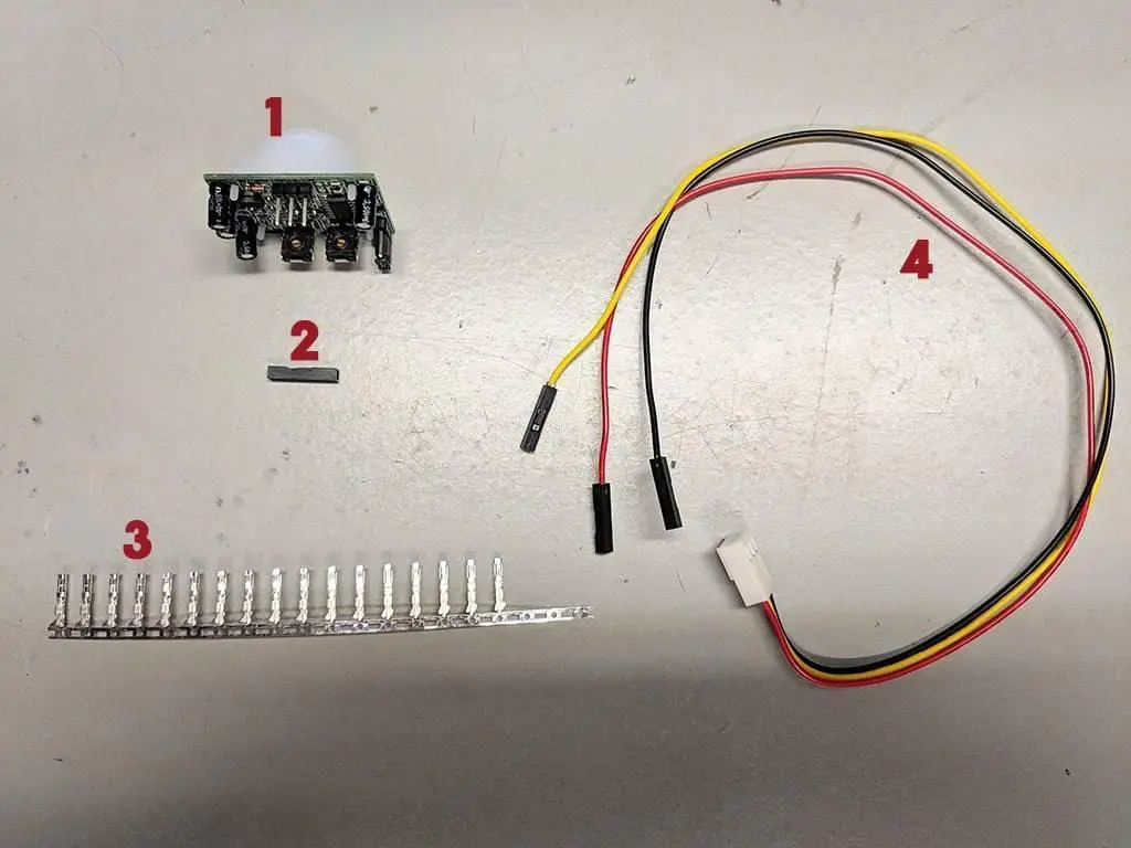 Passive infrared sensor parts laid out on a table and labeled.